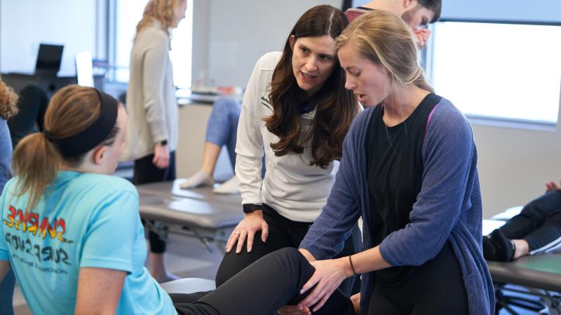 Physical Therapy students checking patient knee